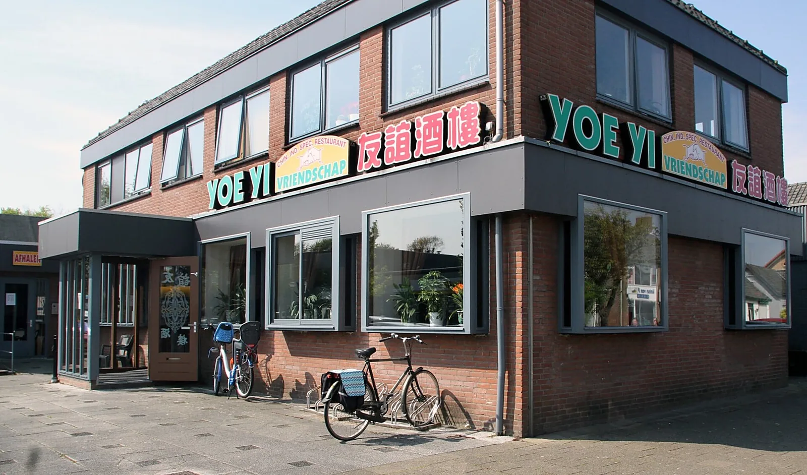 De gevel van Yoe Yi met de groene letters YOE YI, het bord Vriendschap en 友誼酒樓